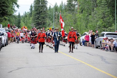 Waskesiu, Saskatchewan, Kanada - 1 Temmuz 2019: The Prince Albert Highlanders Band ve bir RCMP ve Parks Canada Color Guard Kanada bayramını kutlamak için Prince Albert Ulusal Parkı 'nda yürüyüş.