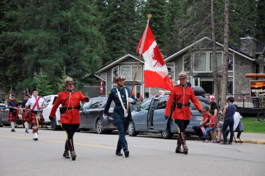 Waskesiu, Saskatchewan, Kanada - 1 Temmuz 2019: The Prince Albert Highlanders Band ve bir RCMP ve Parks Canada Color Guard Kanada bayramını kutlamak için Prince Albert Ulusal Parkı 'nda yürüyüş.