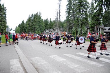 Waskesiu, Saskatchewan, Kanada - 1 Temmuz 2019: The Prince Albert Highlanders Band ve bir RCMP ve Parks Canada Color Guard Kanada bayramını kutlamak için Prince Albert Ulusal Parkı 'nda yürüyüş.