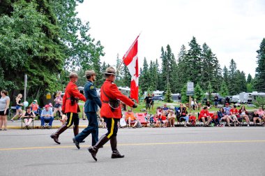 Waskesiu, Saskatchewan, Kanada - 1 Temmuz 2019: The Prince Albert Highlanders Band ve bir RCMP ve Parks Canada Color Guard Kanada bayramını kutlamak için Prince Albert Ulusal Parkı 'nda yürüyüş.