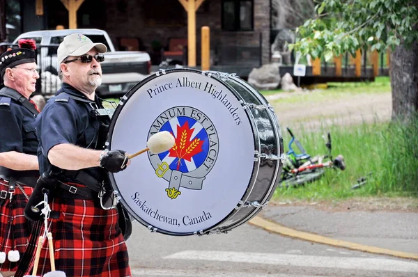 Waskesiu, Saskatchewan, Kanada - 1 Temmuz 2019: The Prince Albert Highlanders Band ve bir RCMP ve Parks Canada Color Guard Kanada bayramını kutlamak için Prince Albert Ulusal Parkı 'nda yürüyüş.