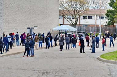 Scarborough, Ontario, Kanada, 6 Mayıs 2021: İnsanlar Scarborough, Ontario, Kanada 'daki 2501 Bridletown Circle, L' Amoreaux Koleji 'nde açılan aşı kliniğinde Covid-19 aşısı kuyruğunda bekliyorlar..