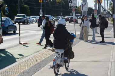 TORONONONONONTO, ONTARIO, CANADA - 15 Ekim 2025: Bisikletçiler bisikletlerini kuzeydoğu Toronto 'daki Steeles Avenue' daki yeni bisiklet yollarında sürüyorlar.