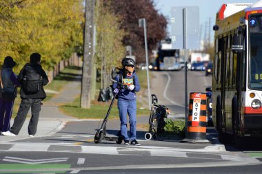 TORONONONONONTO, ONTARIO, CANADA - 15 Ekim 2025: Bisikletçiler bisikletlerini kuzeydoğu Toronto 'daki Steeles Avenue' daki yeni bisiklet yollarında sürüyorlar.