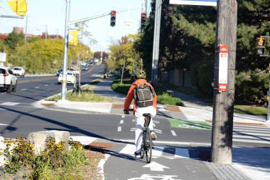 TORONONONONONTO, ONTARIO, CANADA - 15 Ekim 2025: Bisikletçiler bisikletlerini kuzeydoğu Toronto 'daki Steeles Avenue' daki yeni bisiklet yollarında sürüyorlar.