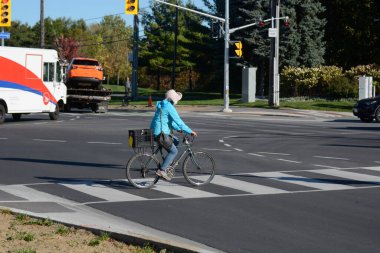 TORONONONONONTO, ONTARIO, CANADA - 15 Ekim 2025: Bisikletçiler bisikletlerini kuzeydoğu Toronto 'daki Steeles Avenue' daki yeni bisiklet yollarında sürüyorlar.