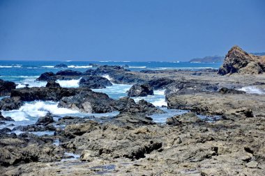Dalgalar Kosta Rika 'nın Guanacaste eyaletindeki Playa San Juanillo' da kayalık kıyılara çarpıyor.. 