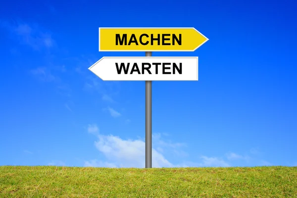 Sign with two arrows shows wait or do german — Stock Photo, Image