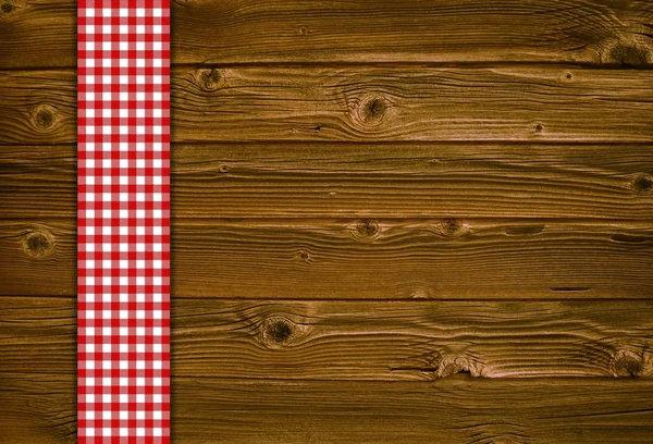 พื้นหลังไม้ด้วยผ้าปูโต๊ะสีแดงสีขาว — ภาพถ่ายสต็อก