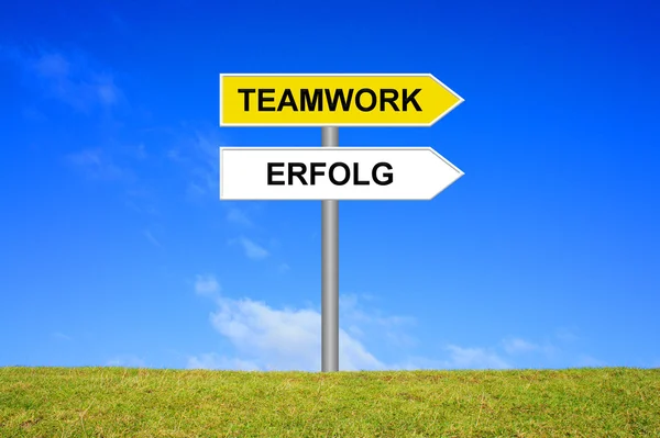 Signpost showing teamwork and success german — Stock Photo, Image