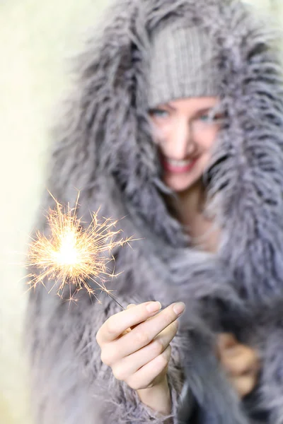 Young smiling woman holding Christmas Sparkler. — Stock Photo, Image