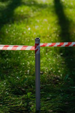 Bariyer bandı doğayı insanlardan ayırıyor. Orman ve park alanı yasak. Ormandaki güneşli çimlerin girişi kapalı. Doğa kavramına saygı.