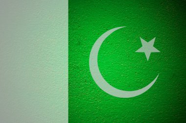 Yeşil duvar arka planında Pakistan bayrağı.