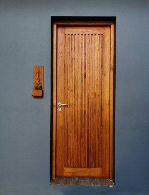 Daire içinde beyaz duvarı olan ahşap bir kapı..