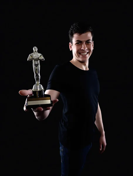 Młody człowiek trzyma fake Oscara award — Zdjęcie stockowe