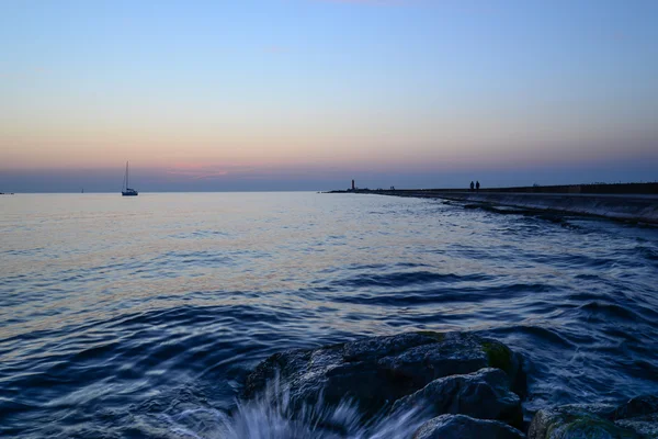 Puesta de sol en el muelle - salpicadura de agua — Foto de Stock