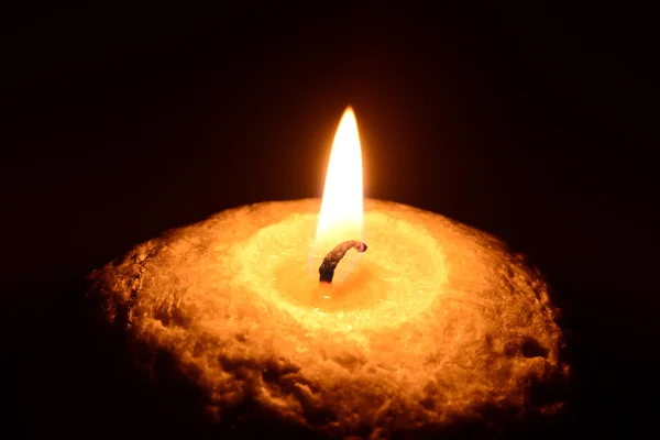 Burning candle on a black background — Stock Photo, Image