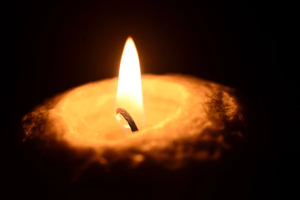 Burning candle on a black background — Stock Photo, Image