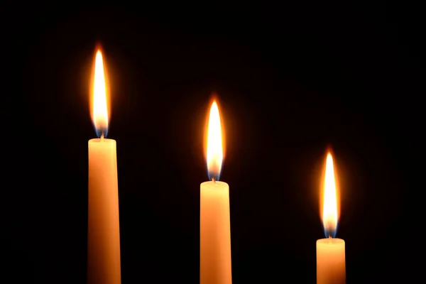 Tři bílé svíčky na černém pozadí — Stock fotografie