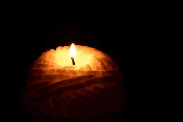 Gelbe Kerze brennt auf schwarzem Hintergrund — Stockfoto