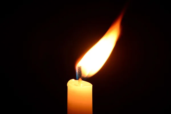 Bílá svíčka hoří na černém pozadí — Stock fotografie