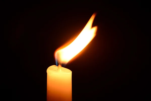 White candle burning on a black background — Stock Photo, Image