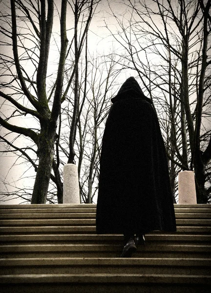 Man in a robe climbing stairs — Stock Photo, Image