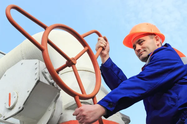 Trabajador gira válvula de gas grande —  Fotos de Stock