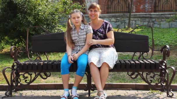 Mère câlins fille sur banc 