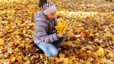 Kız oturuyor ve yaprakları tutar