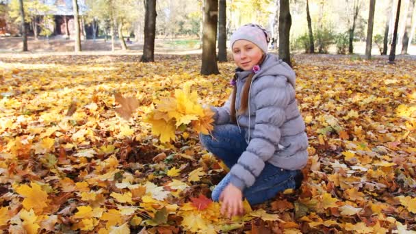 Flicka samlar fallande löv — Stockvideo