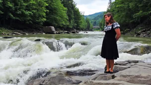 Жінка стоїть в передній водоспад — стокове відео