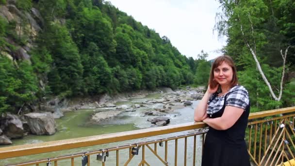 Žena na mostě pak vypadá na řece — Stock video
