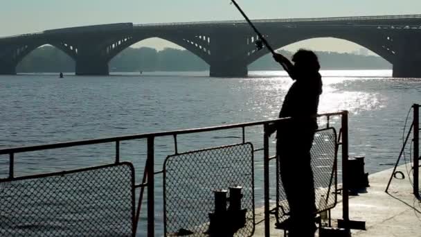 Silhouet van visser op de kust rond de rivier — Stockvideo