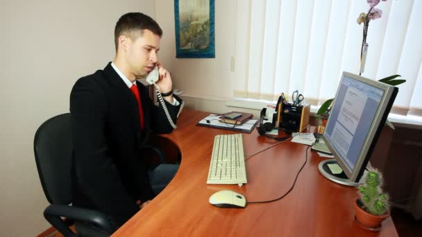 Hombre en el teléfono tomando notas en el trabajo — Vídeo de stock