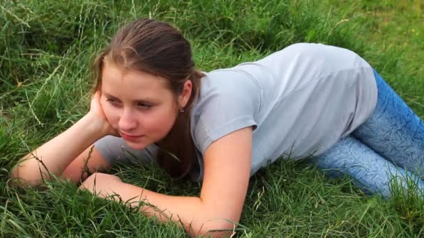 Meisje ligt op groen gras — Stockvideo