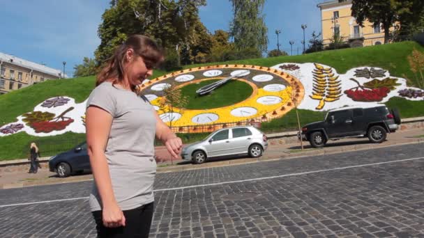 Woman Looks At Hour On Flower Clock — Stock Video