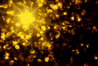 Siyah arka planda bulanık altın bokeh. Altın gibi parlak bir arka plan. Odaklanamayan soyut arkaplan.