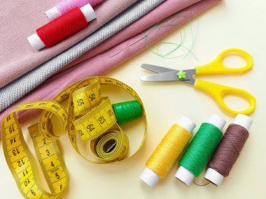 İplik makaraları, mezura, renkli tekstil ve makas. Dikiş, dikiş, nakış malzemeleri ve aksesuarlar..