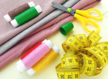 İplik makaraları, mezura, renkli tekstil ve makas. Dikiş, dikiş, nakış malzemeleri ve aksesuarlar..