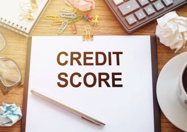Kredi Puanı gösteren metin. Finansal Derecelendirme Rekoru yazma işi. Beyaz kağıda yazılmış, ofis görünümünde ahşap arkaplan kalem, kahve, hesap makinesi