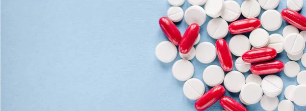 Weiße Tabletten Und Rote Pillis Löffel Auf Blauem Hintergrund — Stockfoto