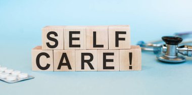 Öz Bakım, tahta küplere yazılmış. Kendi sağlığıyla ilgilenmek için ilaç konsepti