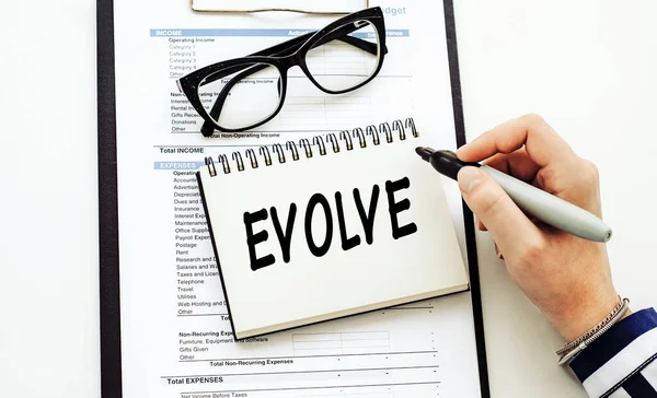 evolve. text on white notepad on documents