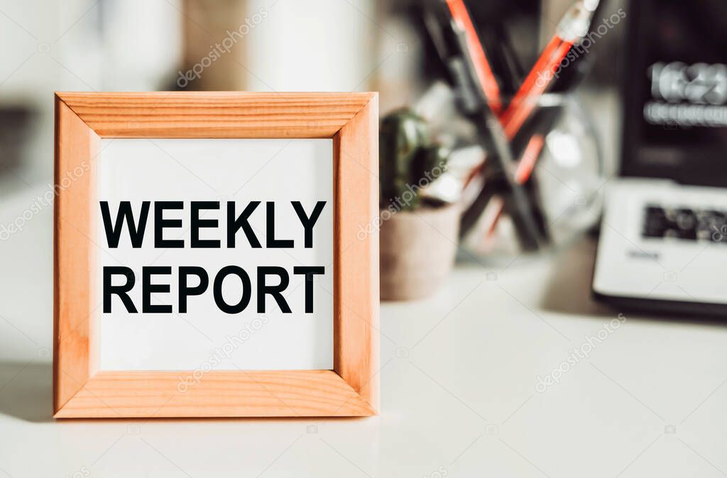 Wooden frame with office background with text Weekly Report. Business concept