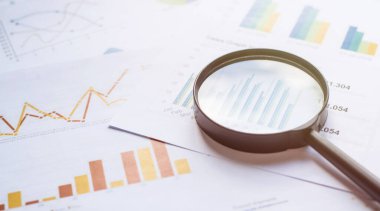 Belgelerde büyüteç olan iş konsepti. İş aşıları ve grafikleri