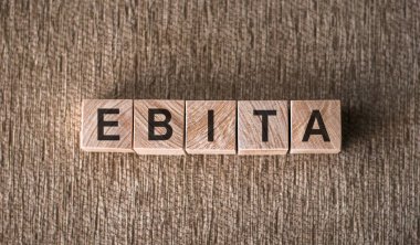 Kahverengi arka planda EBITA 'daki harfler (faiz, vergi, değer kaybı ve amortisman öncesi kar) bloğu. Mali konsept.