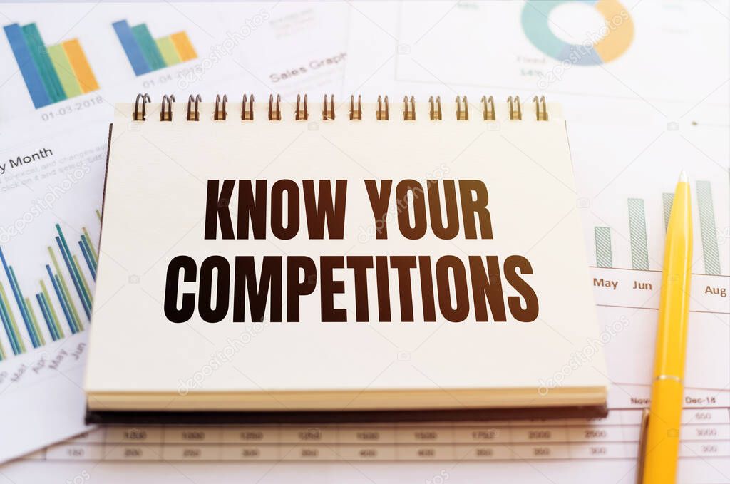 KNOW YOUR COMPETITION text written in a notebook with a pen on financial documents.