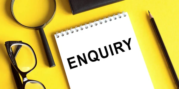 ENQUIRY word written on notepad. ENQUIRY text on table for your desing
