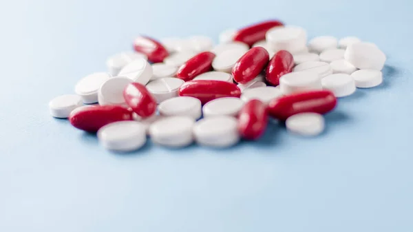 Apothekenthema Weiße Und Rote Medikamententabletten Antibiotika Pillen Auf Blauem Hintergrund — Stockfoto
